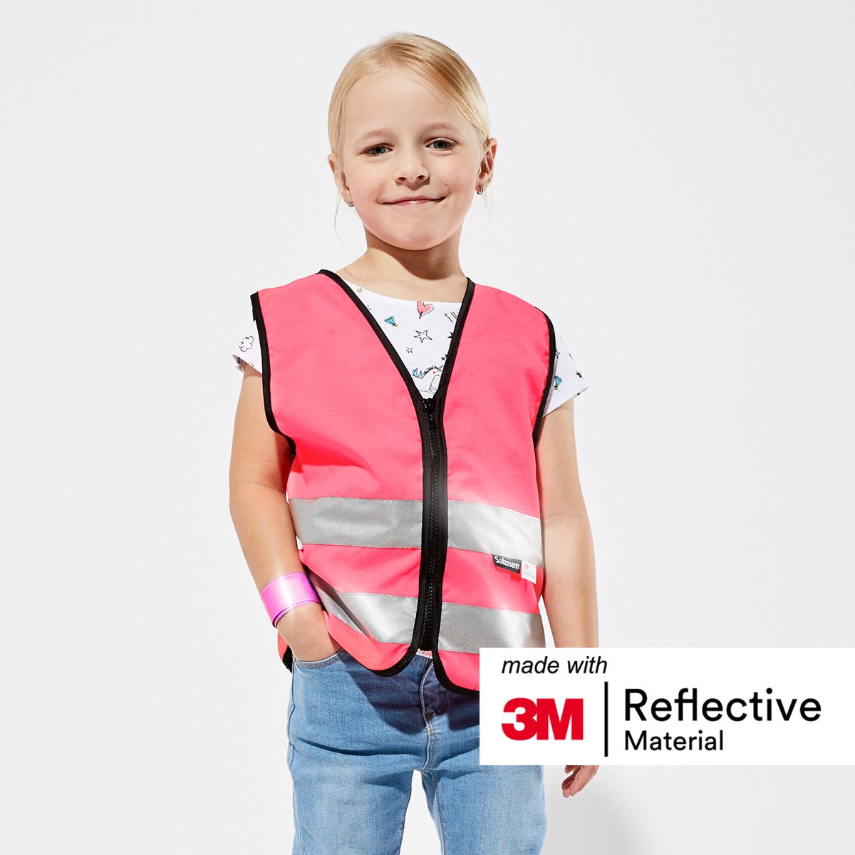 Girl stood smiling with hand in pocket wearing a Pink reflective safety vest