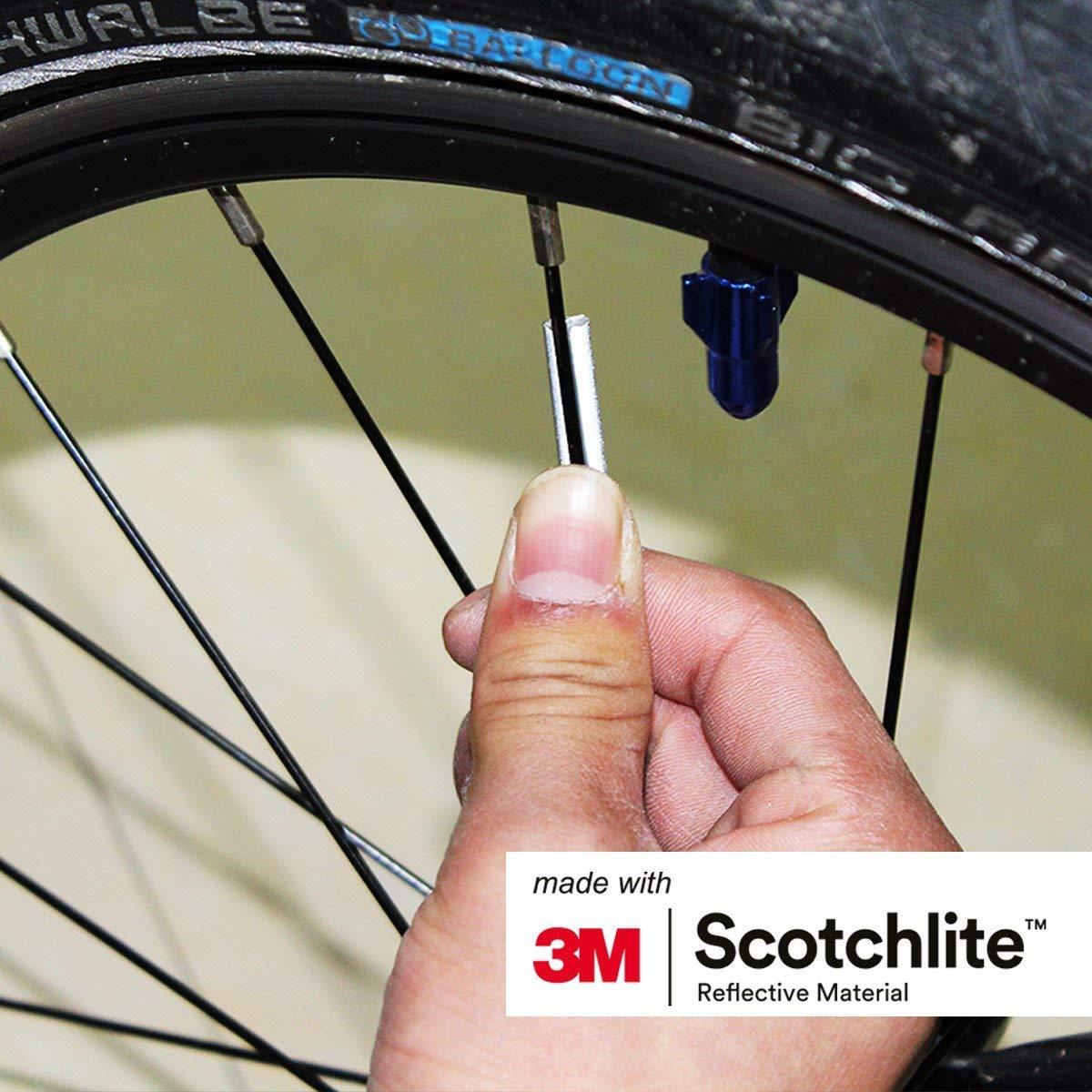 Close up of person pushing a spoke reflector on to a bicycle spoke.