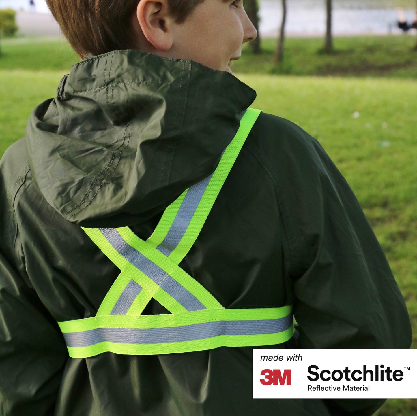 Back of child stood outside wearing the cross belt