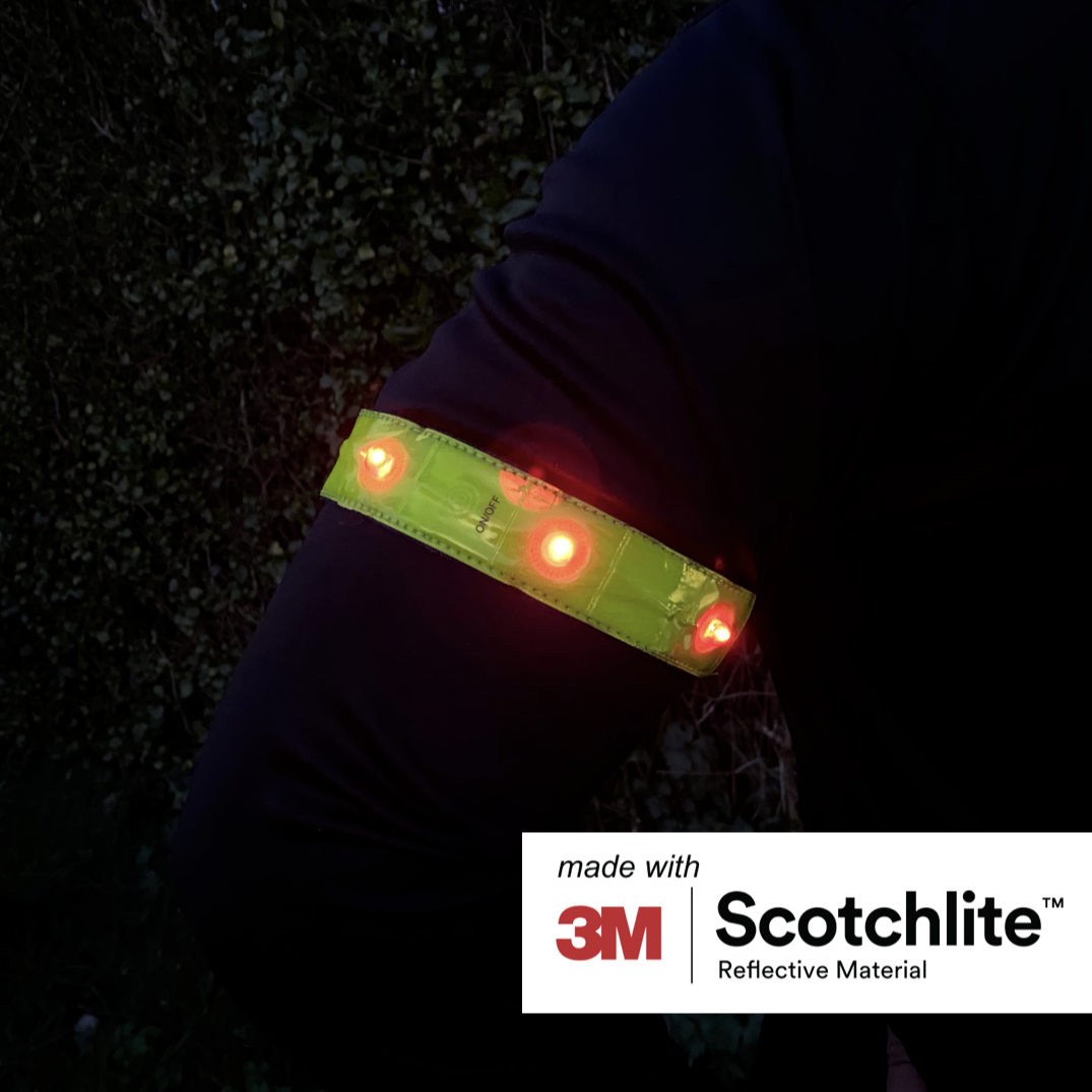 Close-up of persons arm wearing the reflective band outside at night.