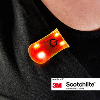 Close-up of persons shirt wearing the magnetic clip with 4 red LED lights turned on.