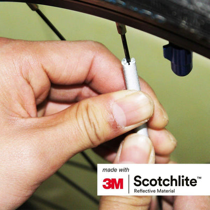 Close up of person fastening a spoke reflector on to a bicycle spoke.